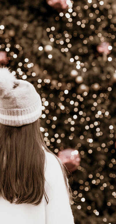 Girl wearing beanie looking at holiday lights