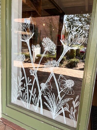 Hand drawn spring flowers  on storefront windows of Cheshire, Connecticut business