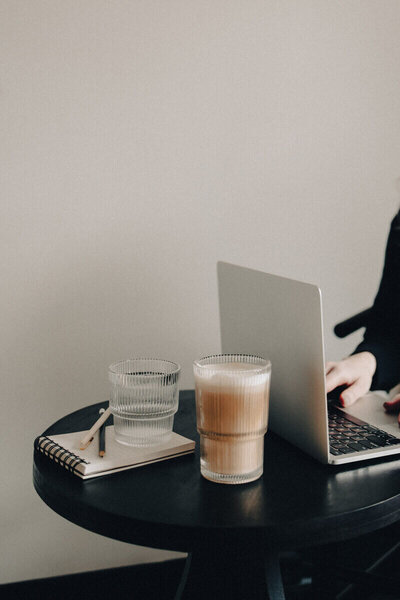 A woman engaged with her laptop at a table, surrounded by the inviting atmosphere of Meteor Street Studio.
