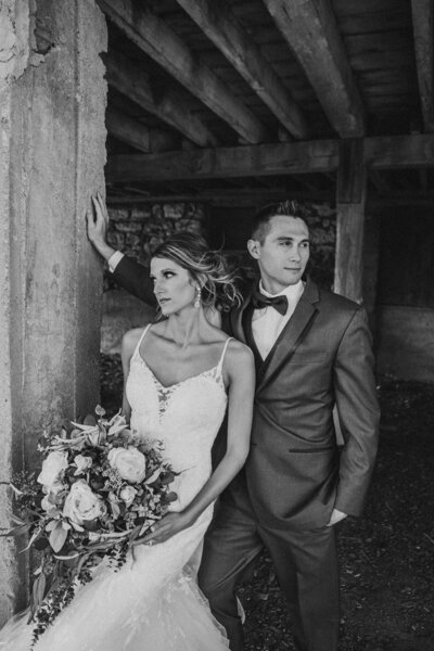 Black and white photo of bride and groom looking opposite directions