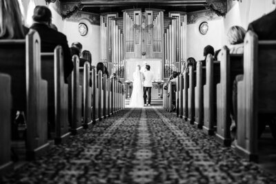black and white cermeony aisle shot of bride and groom at the alter of neighborhood church of palos verdes california