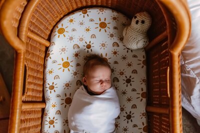 Newborn baby sleeping in harry potter bassinet in Chicago, IL