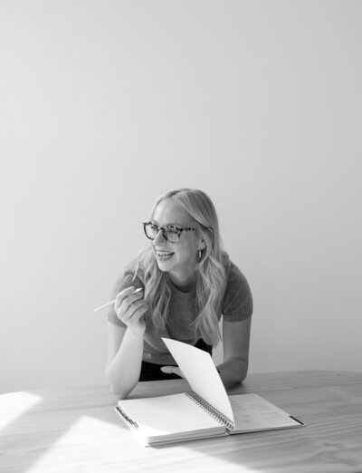 clean film headshot of woman business owner with journal, laughing, natural light studio photography in Michigan