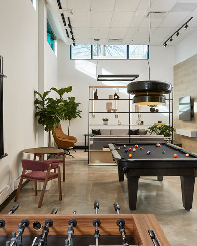 A vibrant lounge featuring foosball and pool tables and elegantly  decorated seating areas