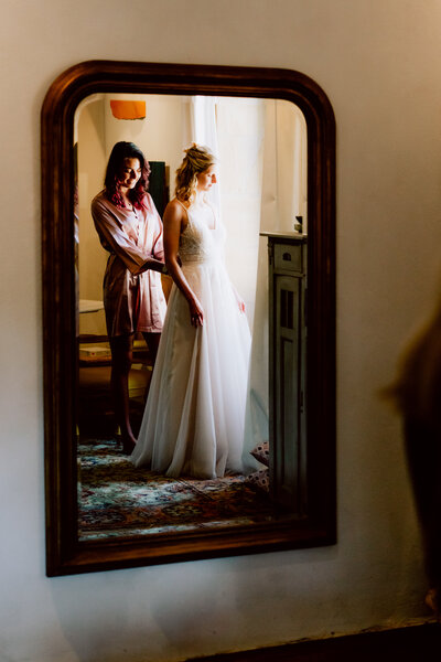 Bruid en make-up artiest staan voor spiegel