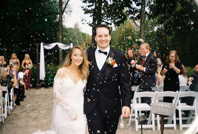 Bride and groom walking back up the aisle, smiling and celebrating.