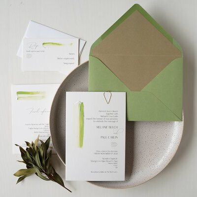 Green painted wedding invitations with details cards and green and gold envelope