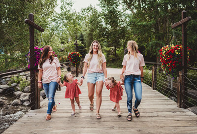 Sisters-and-daughters-walking-on-bridge-wearing-pink-Sisters-marketing-co