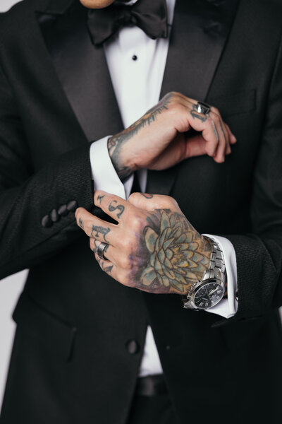 Groom adjusting cufflinks on wedding day — timeless detail photography by The Proper Collective in Des Moines.