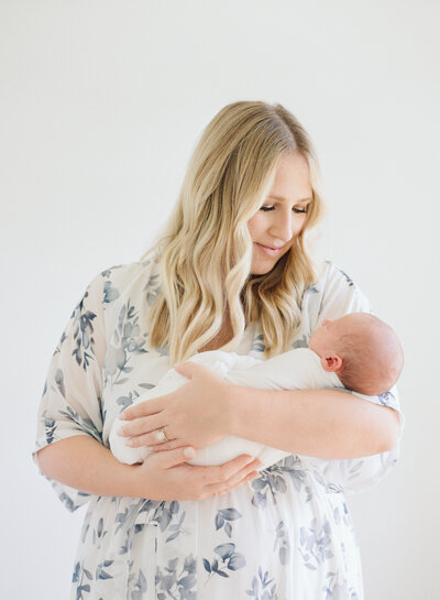 New mom cradling her son during his newborn session. Image by Raleigh newborn photographer A.J. Dunlap Photography.
