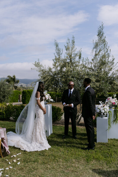 Keiyana and Chase standing at their wedding ceremony with the officiant.