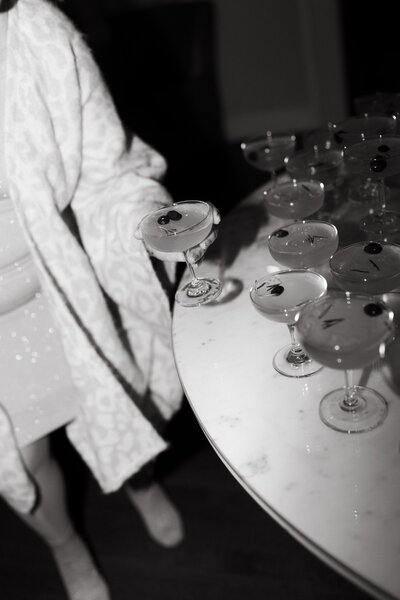 An editorial moment of a woman grabbing a cocktail during cocktail hour at a wedding. 