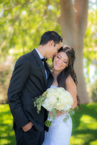 Best Sacramento wedding photographer philippe studio pro captures bride and groom touching heads after wedding ceremony for portraits.