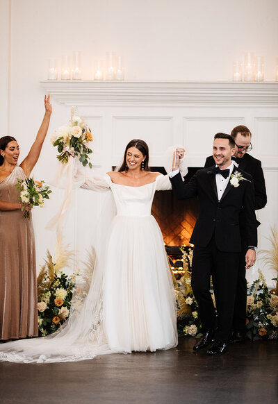 Bride and groom celebrate after their wedding ceremony with a burgundy and pink bouquet  at Lionsgate Event Center North of Denver, Colorado.