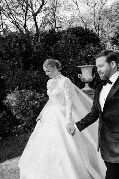 Bride & groom walking while holding hands in the gardens of Villa Balbiano in Lake Como, Italy.