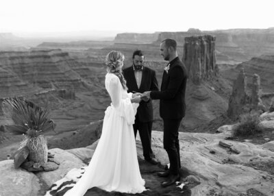 bride and groom facing eachother during wedding ceremony in front of canyon