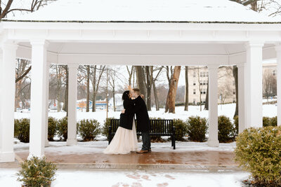 Couple kissing in a gazebo with snow all around