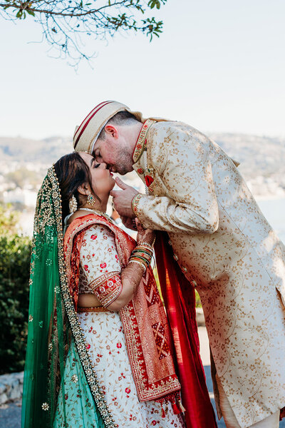 Groom kisses his bride in traditional Muslim ceremonial wedding attire