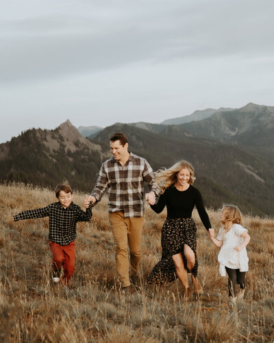 family runs through a field in olympic national park