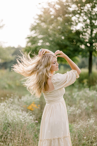 girl flipping hair in a field