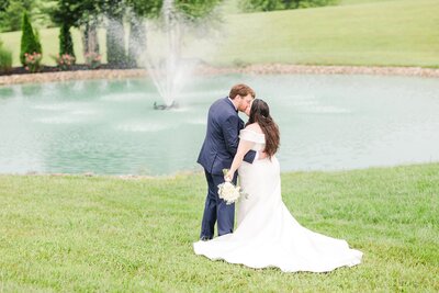 Nashville bride and groom kissing in front of a water display at The White Dove Barn on their Nashville wedding day