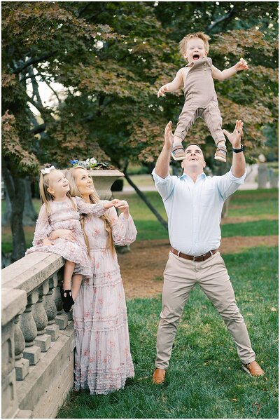 Dad throwing boy in air while mom and sister watch by Atlanta Family Photographer