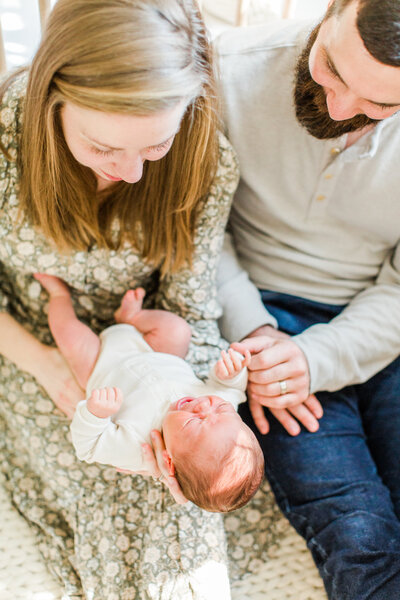 mother and father holding newborn baby