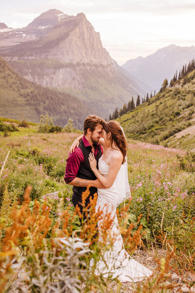 Couple eloping in Glacier National Park in a field of wildflowers