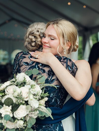 Bride hugging mother at wedding in Frederick MD, by wedding photographers