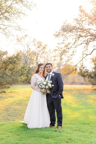 A bride and groom in a field during golden hour at their destination wedding venue.