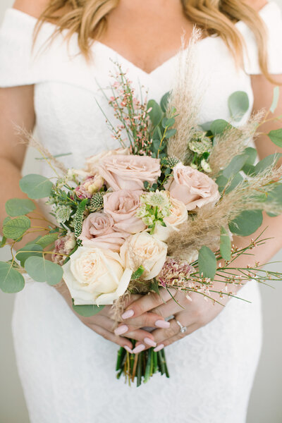 Picture of Blonde Female from neck to thighs holding pink & white bridal bouquet in front of waist