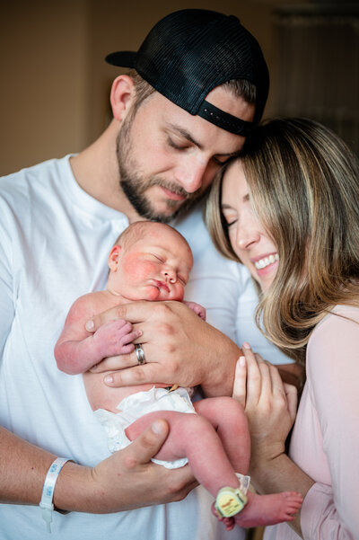 Parents embracing their newborn with joy and love — heartfelt Fresh 48 photography in Aledo by Poppy + Blue Photography
