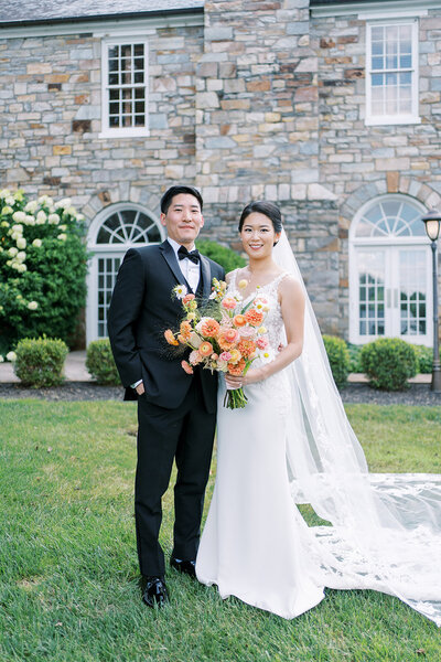 Bride and groom posing outside of a stone building
