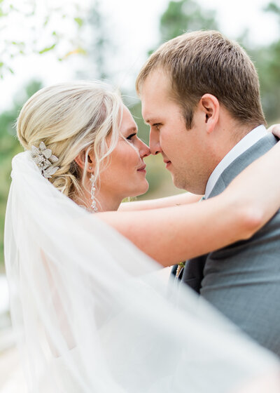 Virginia wedding photographer takes a picture of bride and groom touching noses and snuggling together during photoshoot