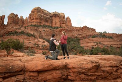 Man gets down on one knee to propose to  his girlfriend in a Sedona