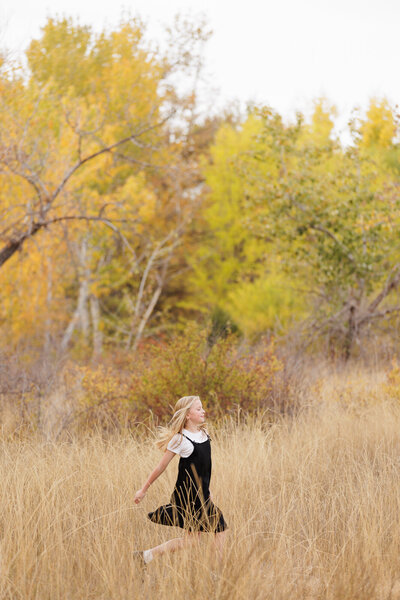 Little girl skipping though a field in Boise.