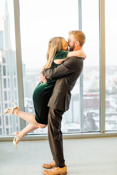 cutest couple leaping into each other's arms after their Nashville Surprise Proposal at the Pinnacle building in downtown Nashville