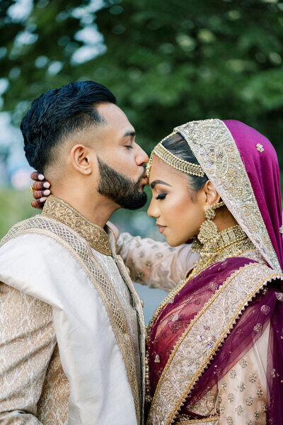 Indian wedding, groom kissing bride forehead