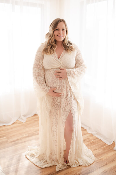 A pregnant mom wearing a white lace gown from Hope's client closet.