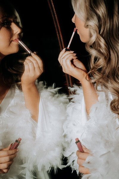 bride applying lip gloss