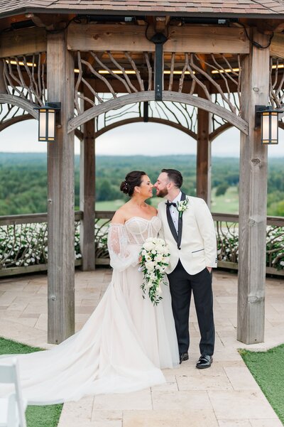 A bride and groom nuzzle noses underneath an overhang in Springfield, MA. 