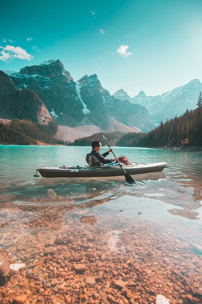Person Kayaking in a Lake near Mountains
