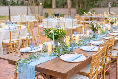 Romantic outdoor wedding table with candles and white charger plates