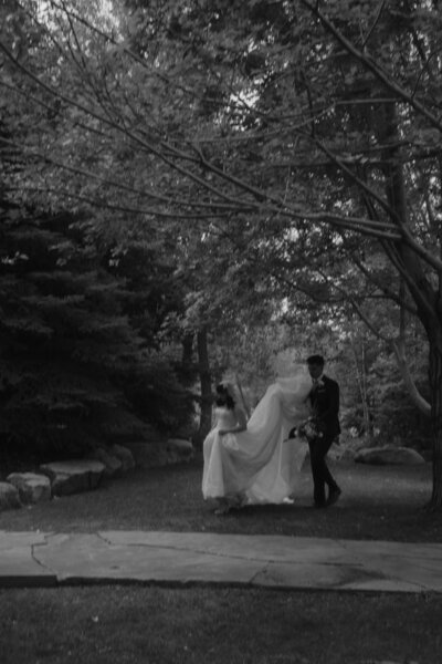 bride and groom hugging one another in a field of grass