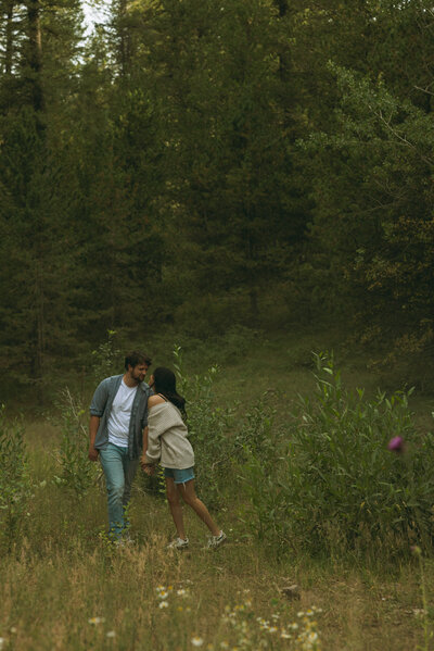 Close up of a couple about to kiss. The man is gently holding his girlfriend's neck, both smiling with their eyes closed.