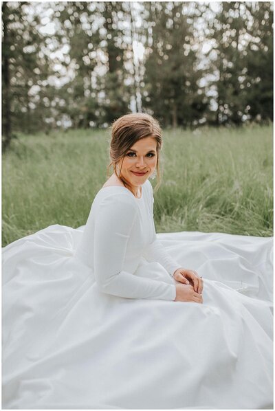 Sacramento Wedding Photographer captures bride sitting in grass on wedding gown