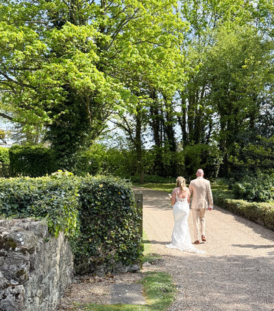 Bride and groom walking away down the driveway