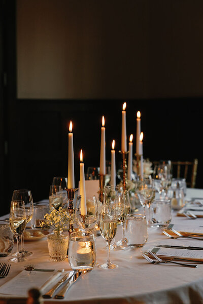 Candlelit wedding table with elegant glasses and table settings.