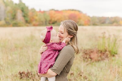 family laughs together during family photo session in Wellesley Massachusetts