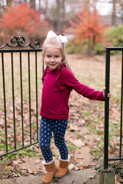 4 year old little girl wears burgundy shirt with navy leggings and boots